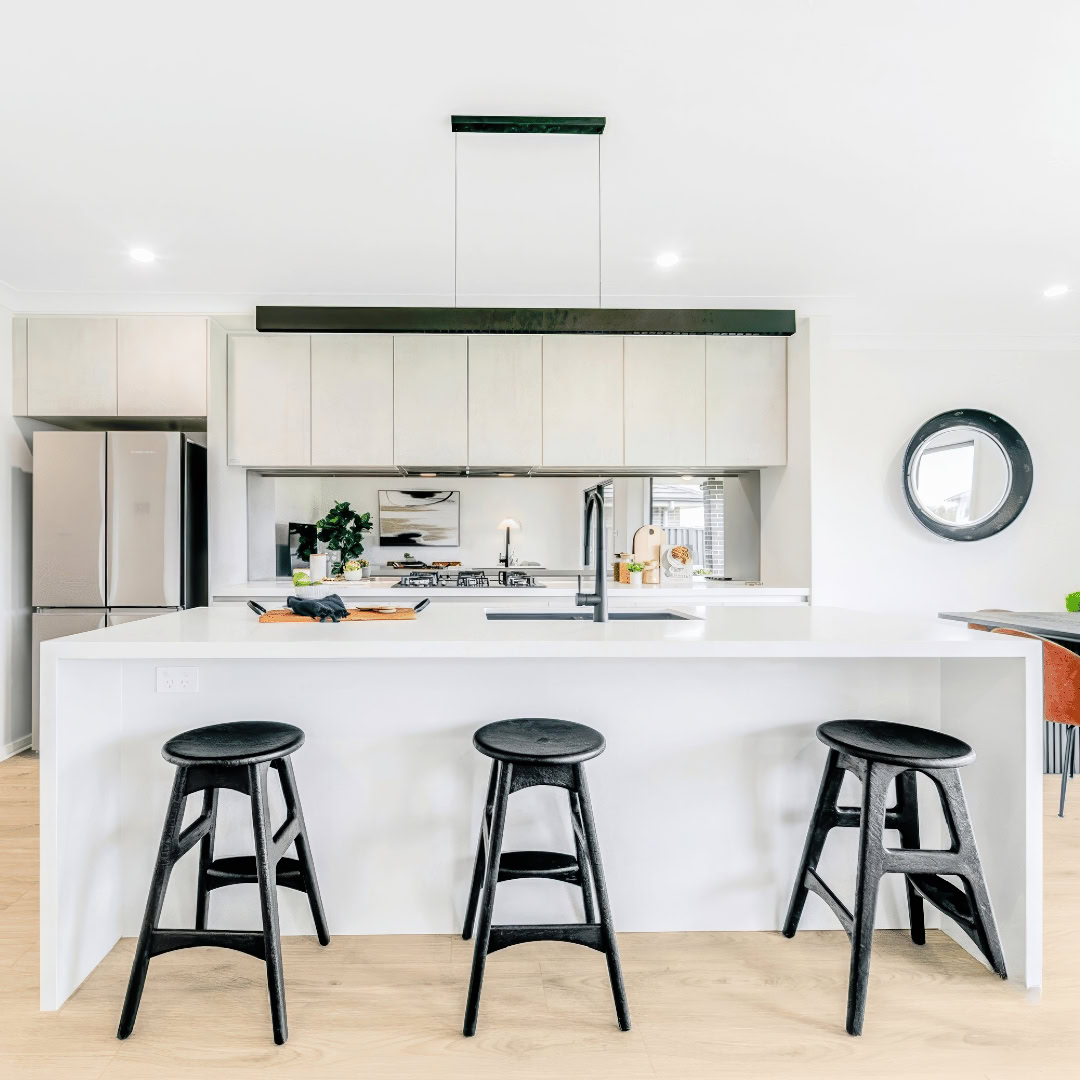 Modern Kitchen with white benchtop, waterfall edges, large black pendant light spanning the length of the counter